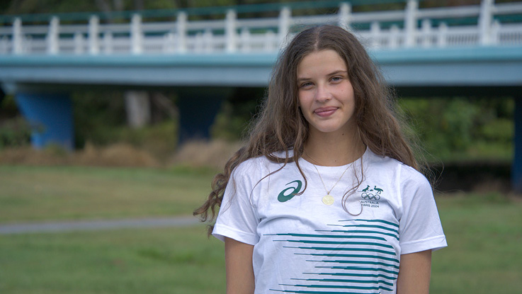 a young girl smiling wearing a white t shirt with green lines